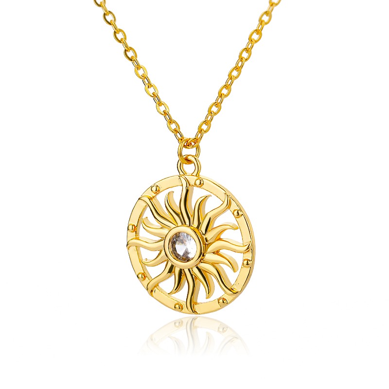 Un collier doré en forme de soleil au milieu d'un cercle sur fond blanc.