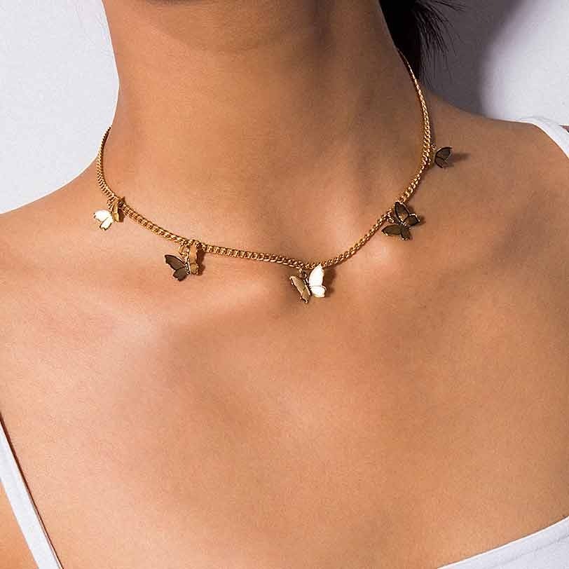 Le cou d'une femme avec un collier papillon en défilé doré.