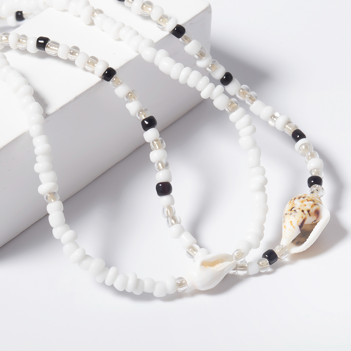 Duo de colliers ras du coup de perles et coquillage blanc