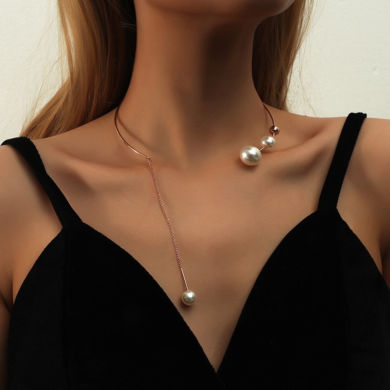 Collier perle de culture pendent porté autour du cou d'une femme.