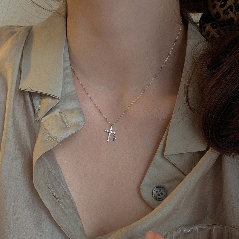 Collier double croix incrusté de zircon autour d'un cou de femme.